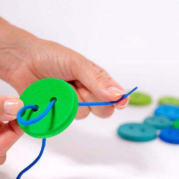 Botones de Colores Ensartables de Madera – Juguete Waldorf de Grimm’s